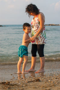 Mother and son standing on beach