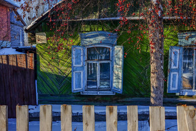 House against blue sky and tree seen through window