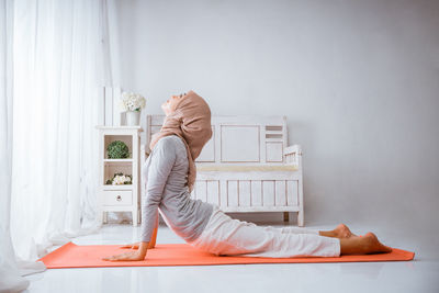 Side view of young woman sitting at home