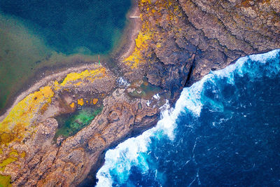 High angle view of rocks on sea shore