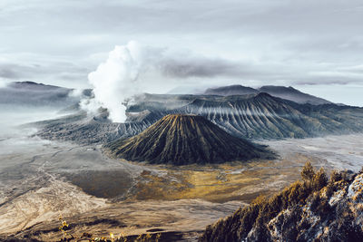 Smoke emitting from volcanic mountain against sky