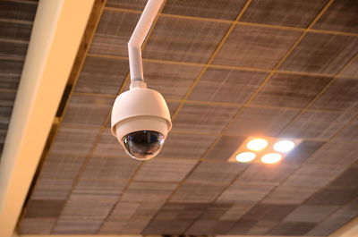 Low angle view of security camera hanging from ceiling