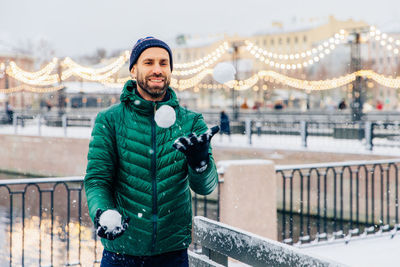 Portrait of young man standing in snow