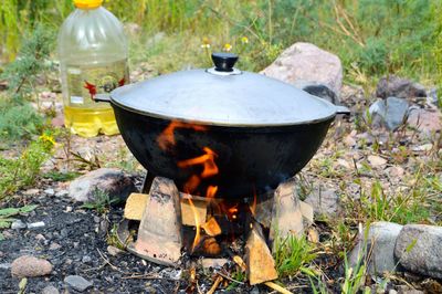 Low angle view of campfire and saucepan