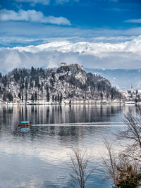 Scenic view of lake and mountain against cloudy sky