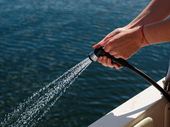 Close-up of hand holding fishing boat in sea