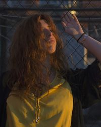 Young woman leaning on fence