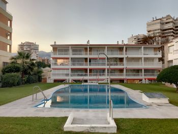 View of swimming pool by building against sky