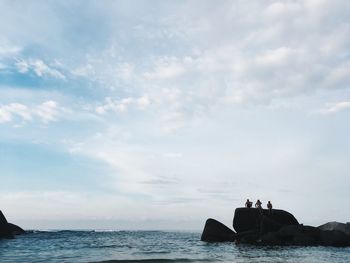 People on boat by sea against sky