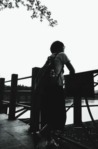 Rear view of woman standing by railing