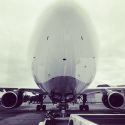 Airplane on airport runway against sky