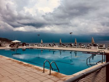 View of swimming pool against cloudy sky