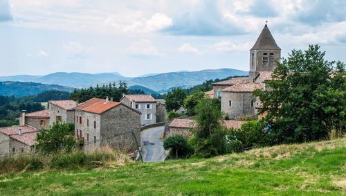 Houses by buildings against sky