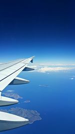 Aerial view of airplane wing over clouds