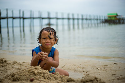 Portrait of a boy playing sand at beach