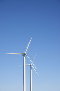 Low angle view of windmill against clear blue sky