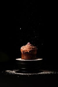 Close-up of cake on table against black background