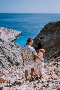 Rear view of couple looking at sea against sky