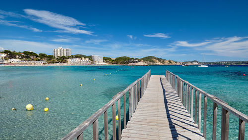 Pier over sea against blue sky