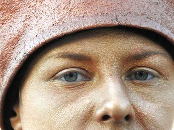 Cropped portrait of person with make-up wearing headwear