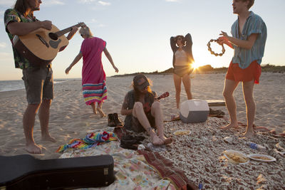 Friends playing music together on a beach