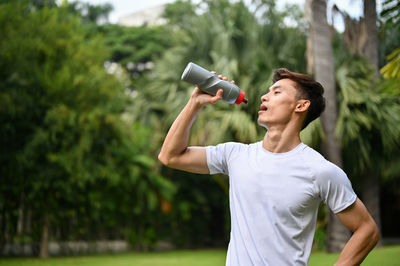 Young man drinking water bottle