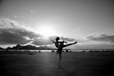 Full length of ballet dancer practicing against sky