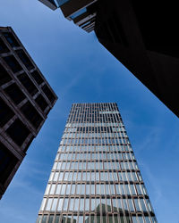 Low angle view of modern buildings against blue sky