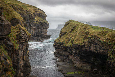 Rock formations by sea against sky