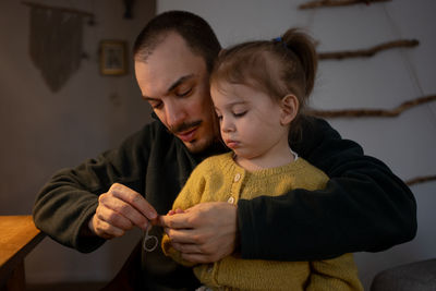 Father clipping nails of daughter