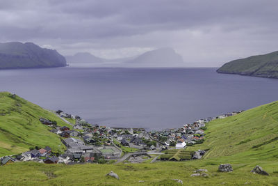 Scenic view of sea by mountains against sky