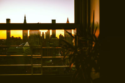 Exterior of silhouette buildings in town against sky during sunset