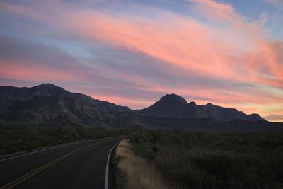 Empty road against sky during sunset