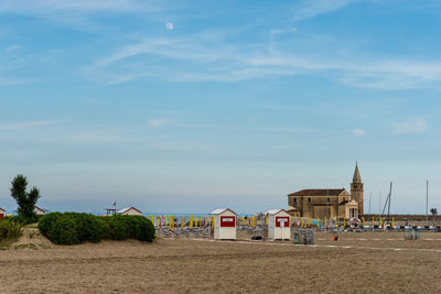 Houses by sea against sky