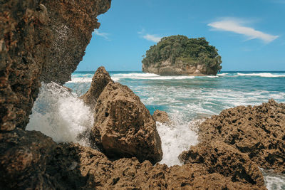 Rocks on beach against sky