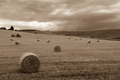 Hay bales on beach against sky