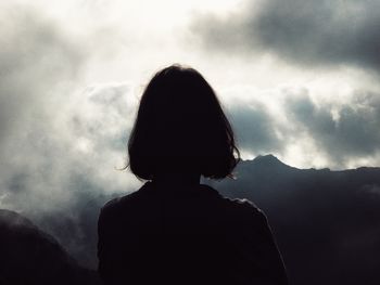 Rear view of silhouette boy against sky