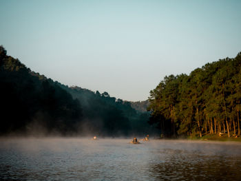 Scenic view of lake amidst trees against sky