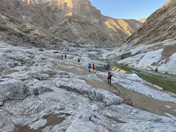 People walking on rocks in canyon 