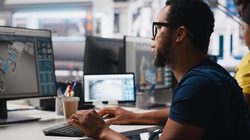 Side view of man using laptop on table