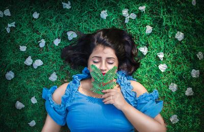 Portrait of woman lying on grassy field