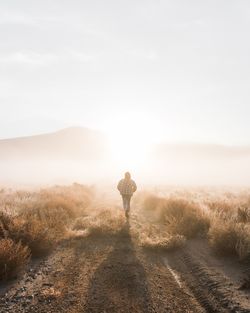 Rear view of man on land against sky