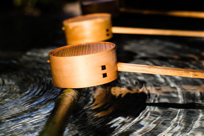 Close-up of wooden ladles over water