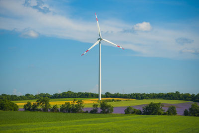 Windmill on field against sky