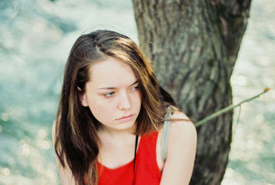 Portrait of teenage girl against tree trunk