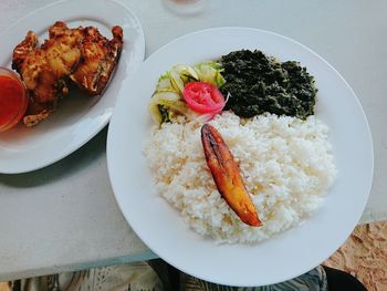 Close-up of fish with rice in plate on table