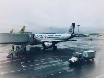 Airplane on airport runway against sky