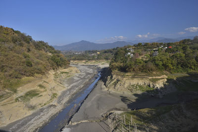 Scenic view of river by mountains against sky