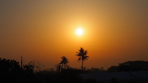 Silhouette palm trees against romantic sky at sunset