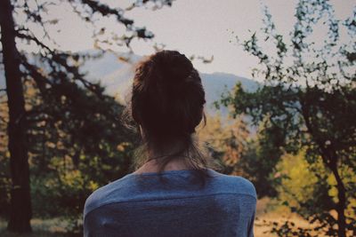 Rear view of woman against trees